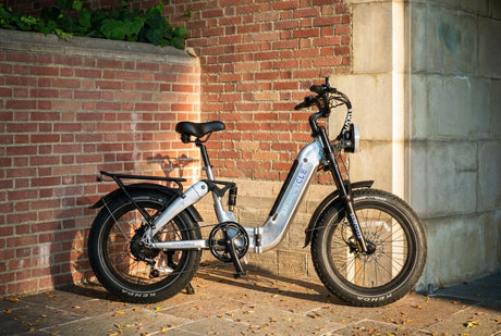Snapcycle Storm step-through fat-tire e-bike parked against a brick wall in warm evening light