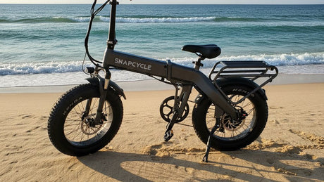 Snapcycle fat-tire folding e-bike on a sandy ocean beach at golden hour