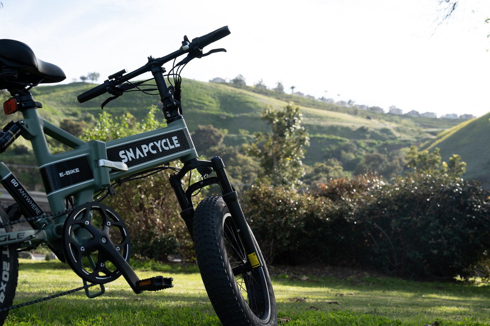 Snapcycle e-bike on a sunny green hillside