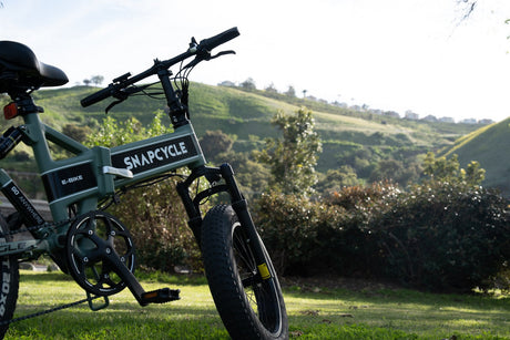 Snapcycle e-bike on a sunny green hillside