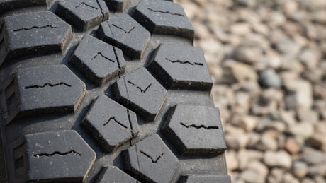 Close-up of a knobby tire tread pattern on gravel