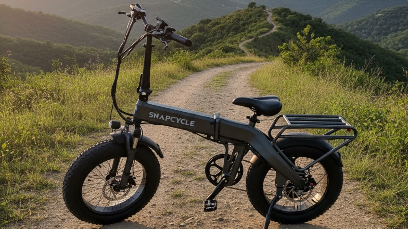 Snapcycle e-bike on a scenic mountain trail at golden hour with green hills behind