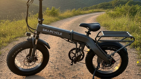 Snapcycle e-bike on a scenic mountain trail at golden hour with green hills behind
